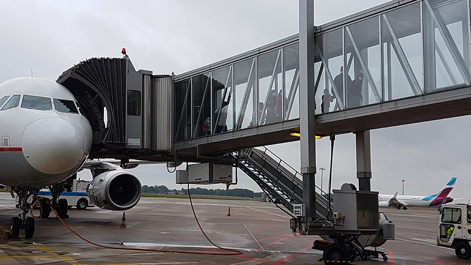 Passagiere steigen durch eine Gangway aus einem Flugzeug aus