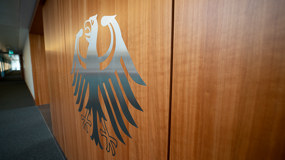 Bild einer hölzernen Wand mit silbernem Bundesadler im Leitungsbereich des Bundesinnenministeriums in Berlin