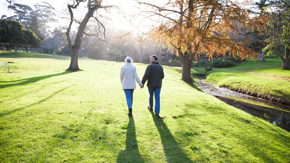 Älteres Paar spaziert durch einen Park