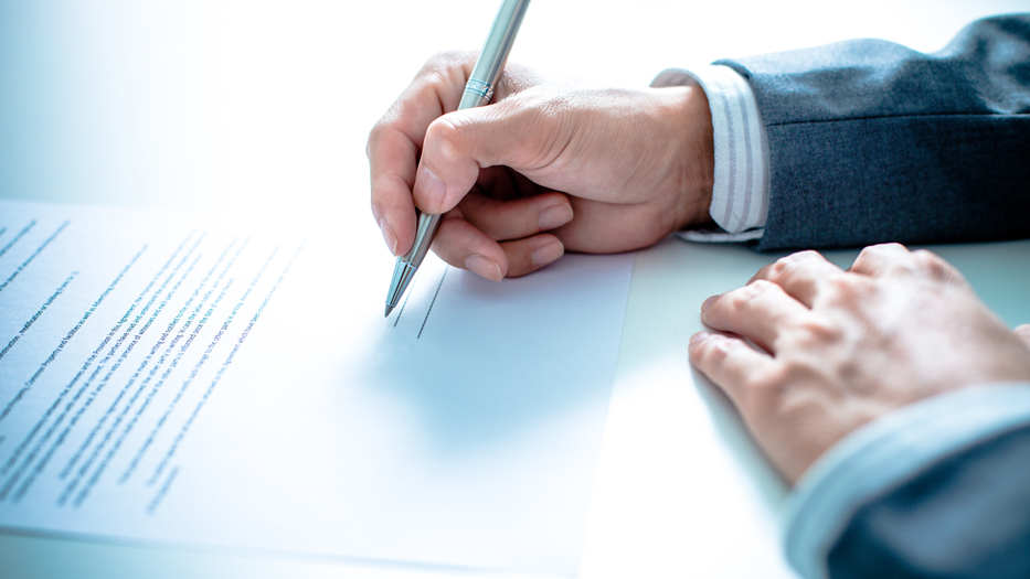 Hand mit Füller unterschreibt ein Dokument