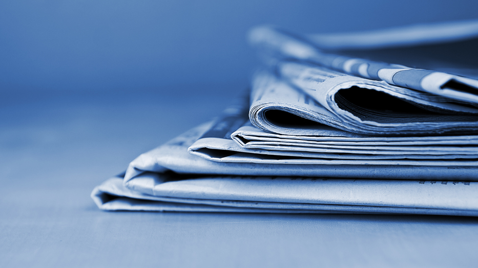 Blau eingefärbtes Bild mit mehreren Zeitungen übereinander gestapelt