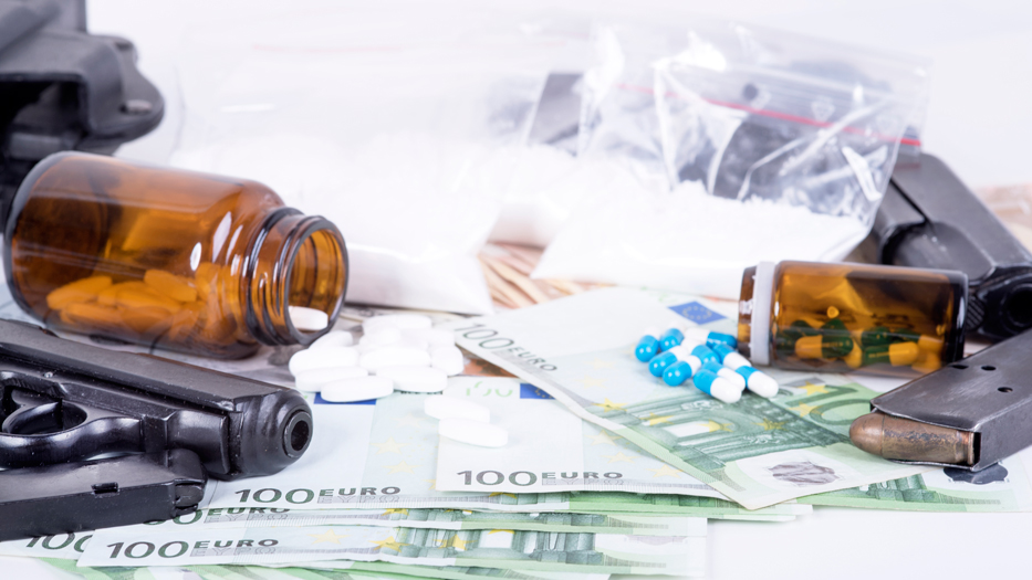 Waffen, Drogen, Medikamente und Geld liegen auf einem Tisch