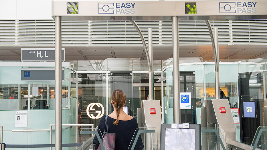 Eine Frau geht durch die EasyPass-Kontrolle am Flughafen