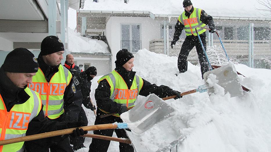 Bereitschaftspolizei hilft bei der Beseitigung von Schneemassen.