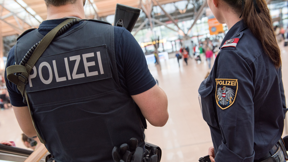 Rückenansicht eines Polizisten und Seitenansicht einer Polizistin