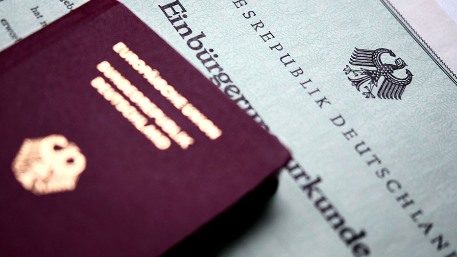 Ein deutscher Pass auf einer Einbürgerungsurkunde
