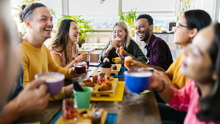 A group of young people are sitting at a table having breakfast