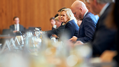 Federal Interior Minister Faeser at a conference table, foreground and background slightly blurred