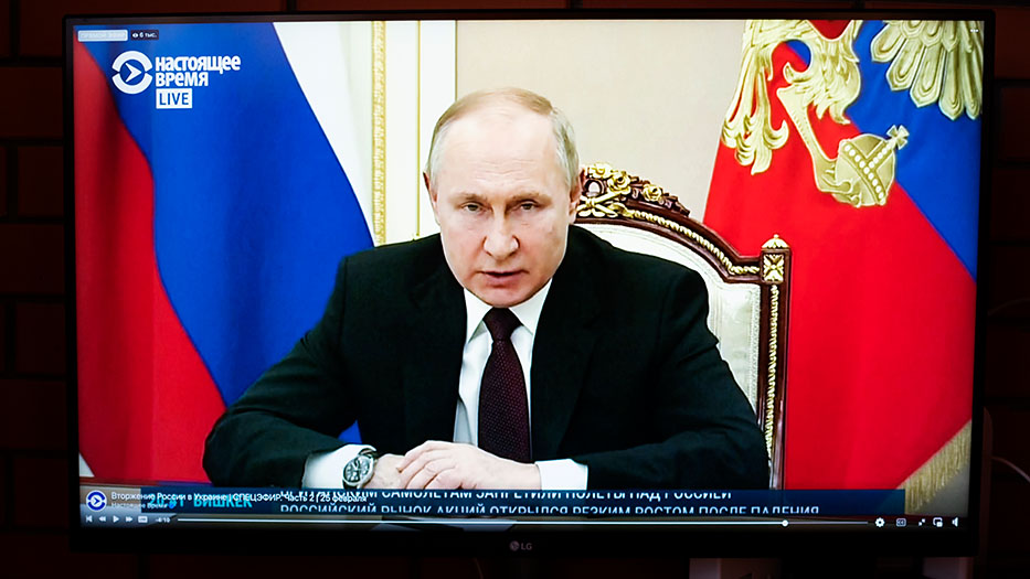 A screen with the face of the Russian President Putin giving a speech on television