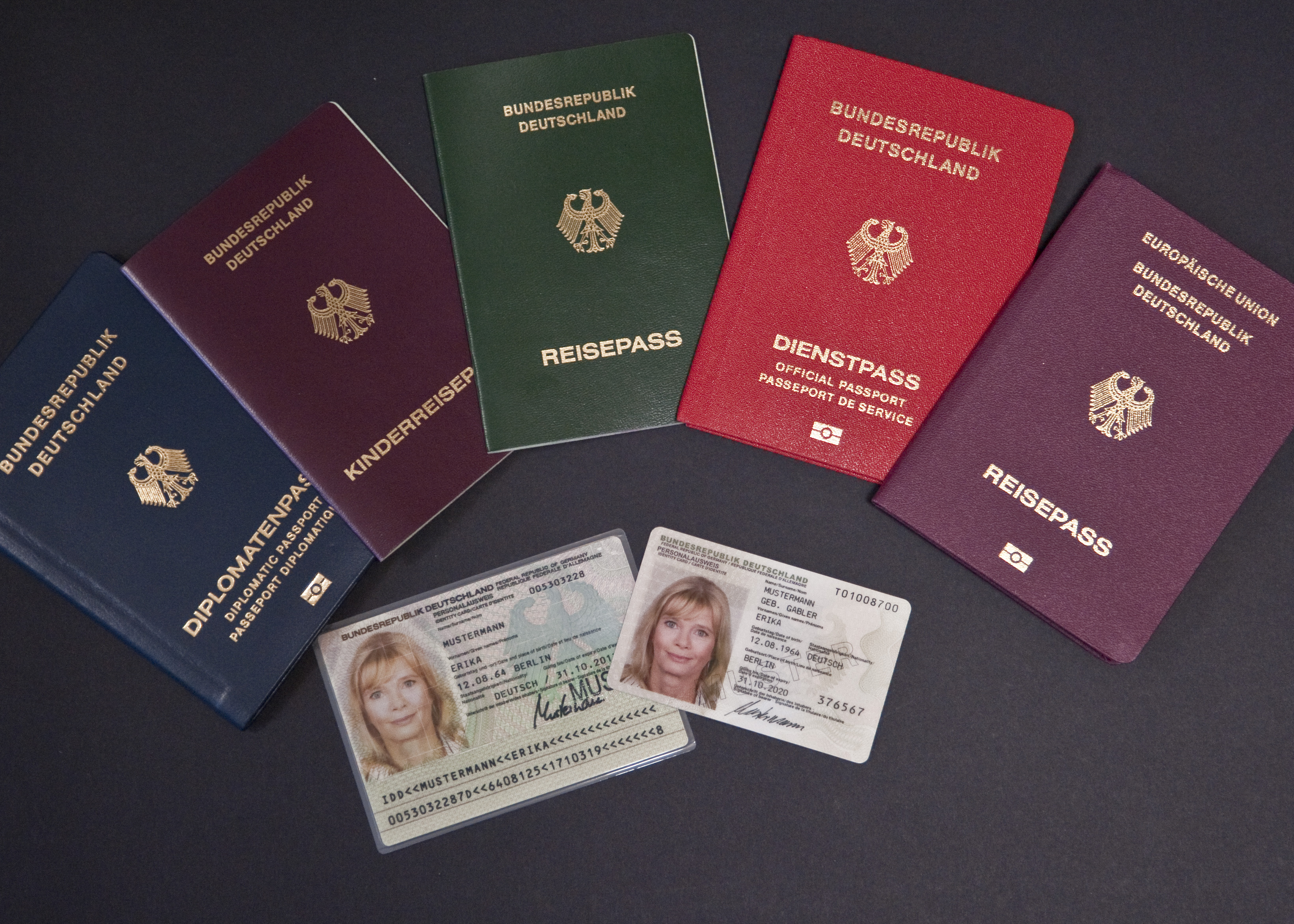 Several different passports as well as the old and new ID card are lying on a black table